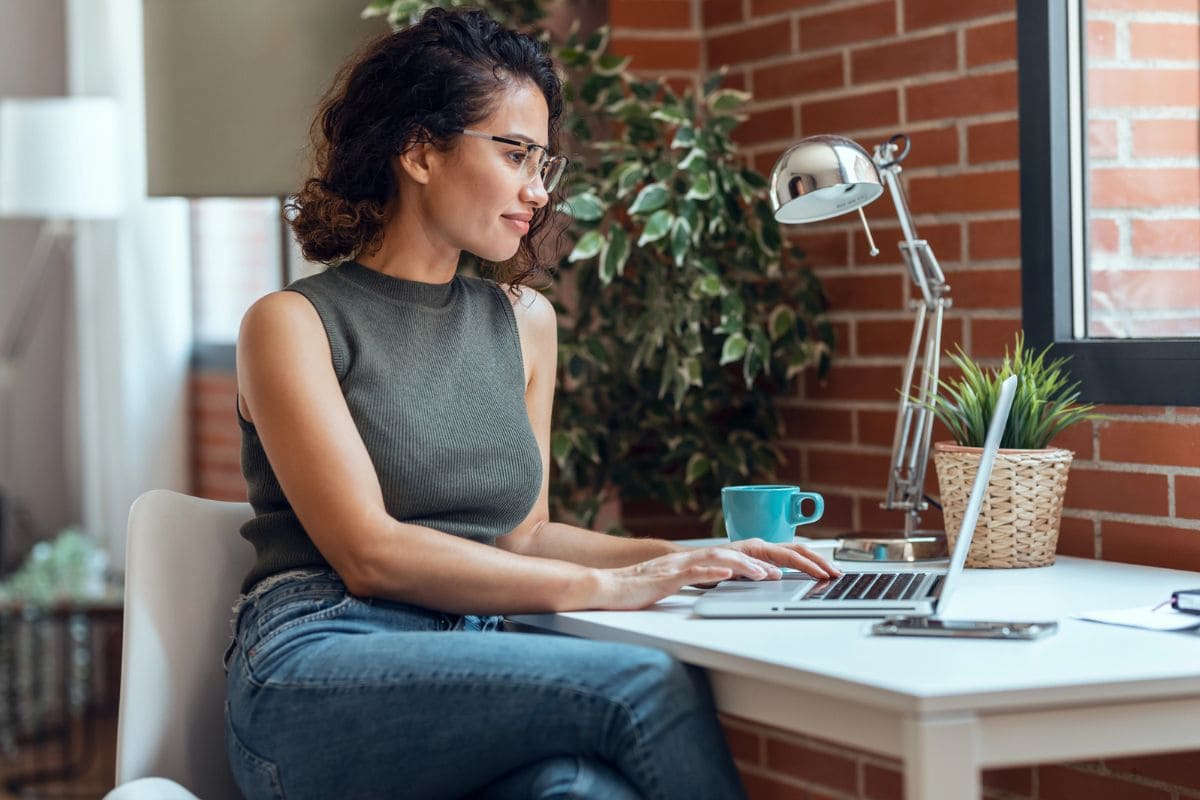 Content creator working from home at a desk and looking out a window for blog post content creation niches