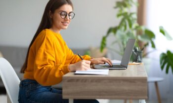 A woman wearing glasses looking for good remote jobs for people with ADHD.