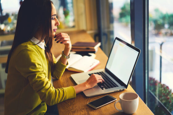 A woman looking for a nonprofit work from home job on her laptop