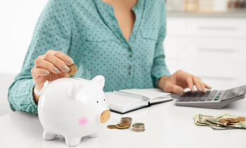 A woman putting money into a piggy bank for blog post things to rent for money