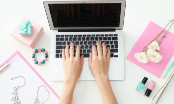 A closeup of a woman typing on a laptop computer for Branded Surveys Review