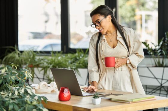 A woman reviewing her career goals on her laptop while drinking coffee.