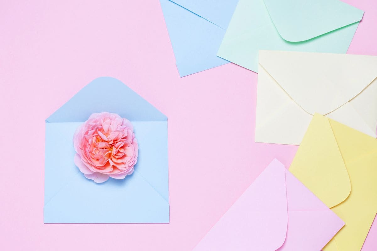 An assortment of greeting cards and envelopes on a flat background for the blog post get paid to write greeting cards from home