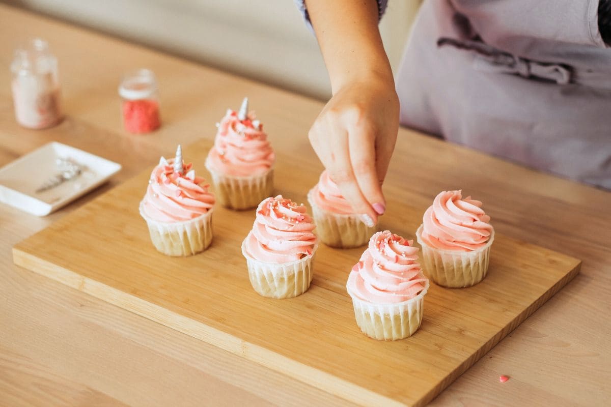 A woman decorating cupcakes in her home bakery.